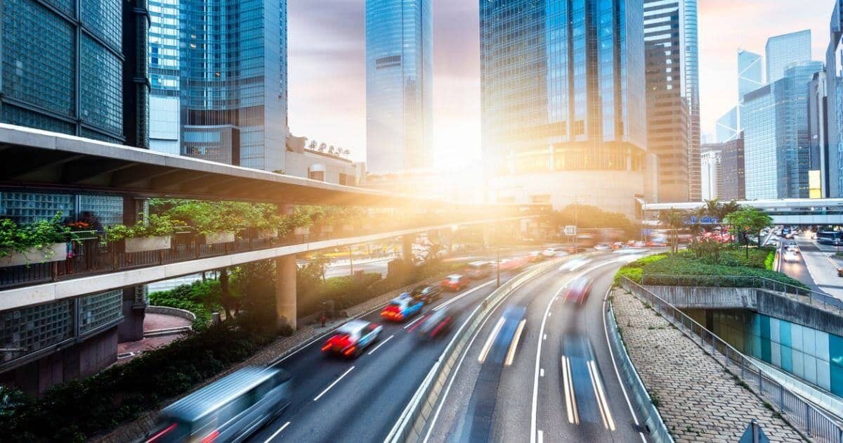 Traffic streaming through a city at sunset, headlights and tail lights drawn out by a long exposure